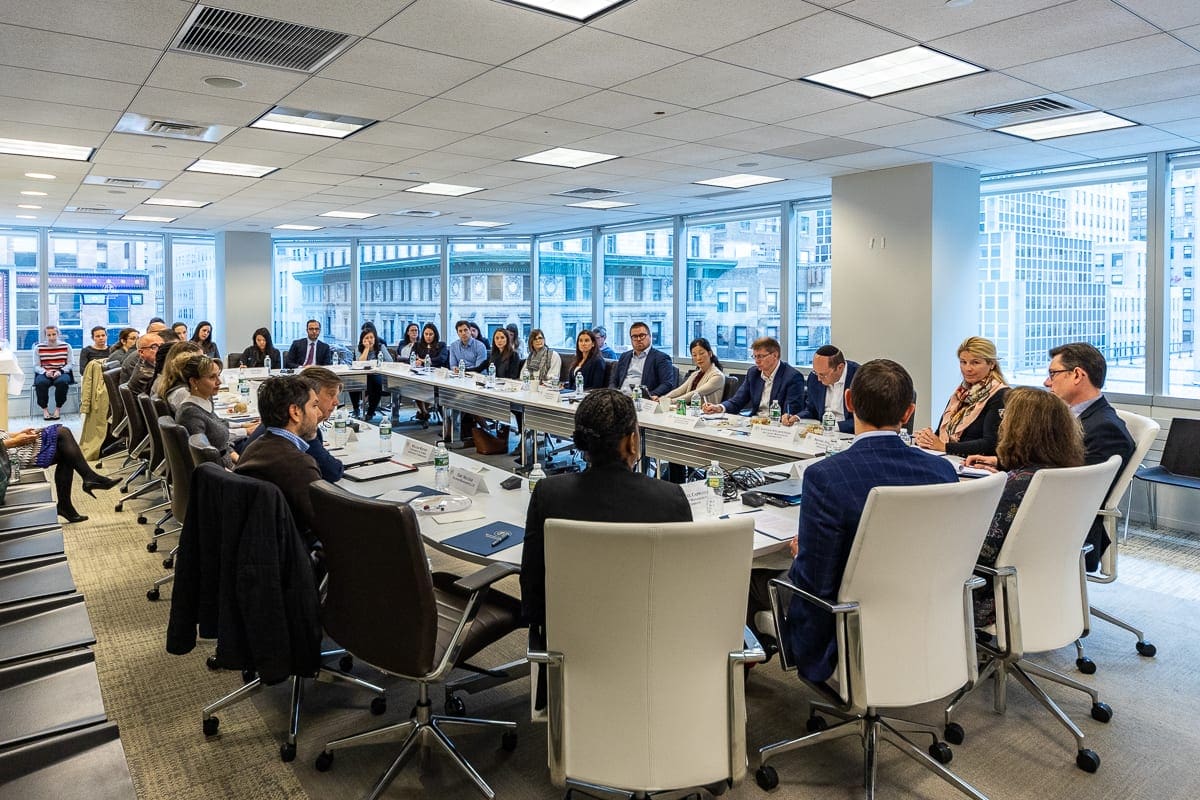 Men and women sit at a conference table discussing environmental, social and governance, or ESG, frameworks at an Eminence forum.